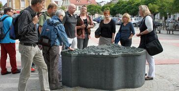 Ein Stadtführer zeigt den Touristen das historische Denkmal am Neustädtischen Markt