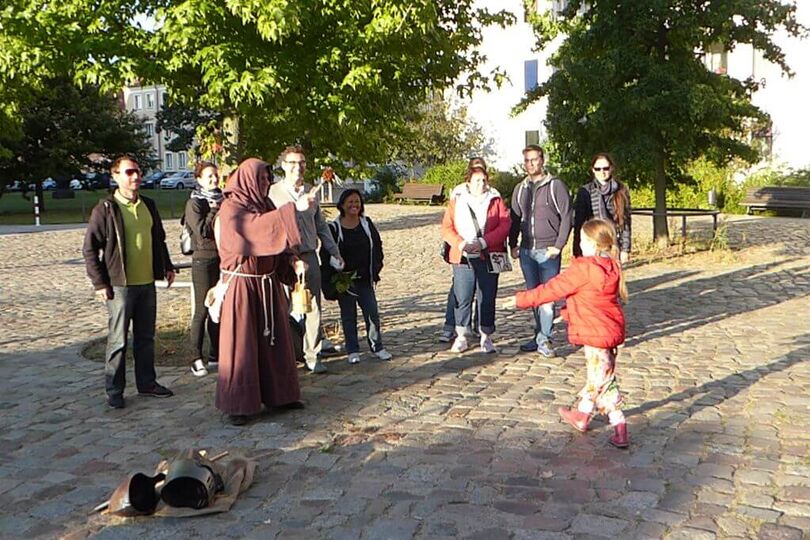 Touristen mit Stadtführer als Möch verkleidet.